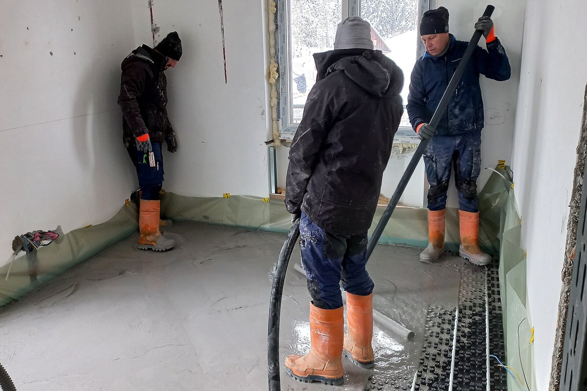 Operai al lavoro durante la posa di un massetto fluido